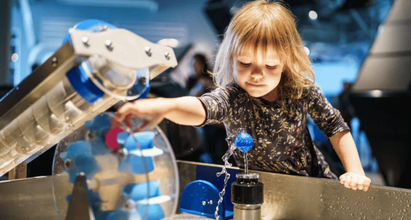 Un enfant joue avec un interactif à l’exposition EXPLORE du centre des sciences de Montréal 